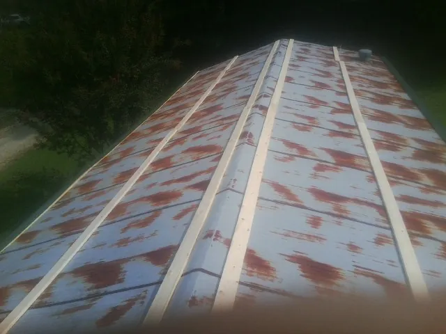 Rusted metal roof panels with new wood purlins before replacement — Storm Damage Roof Repair in Check by Roofing Brothers