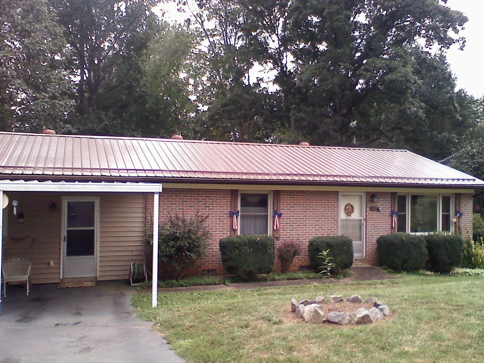 Bronze metal roof and carport on a brick ranch home — Roof Repair work by our crew in Check